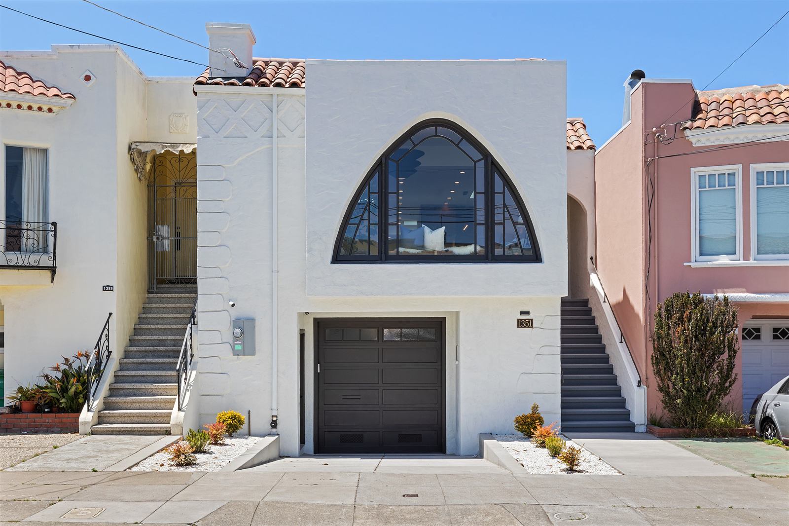 Fully renovated white Spanish revival home with an arched window on 40th Avenue in San Francisco's Sunset District